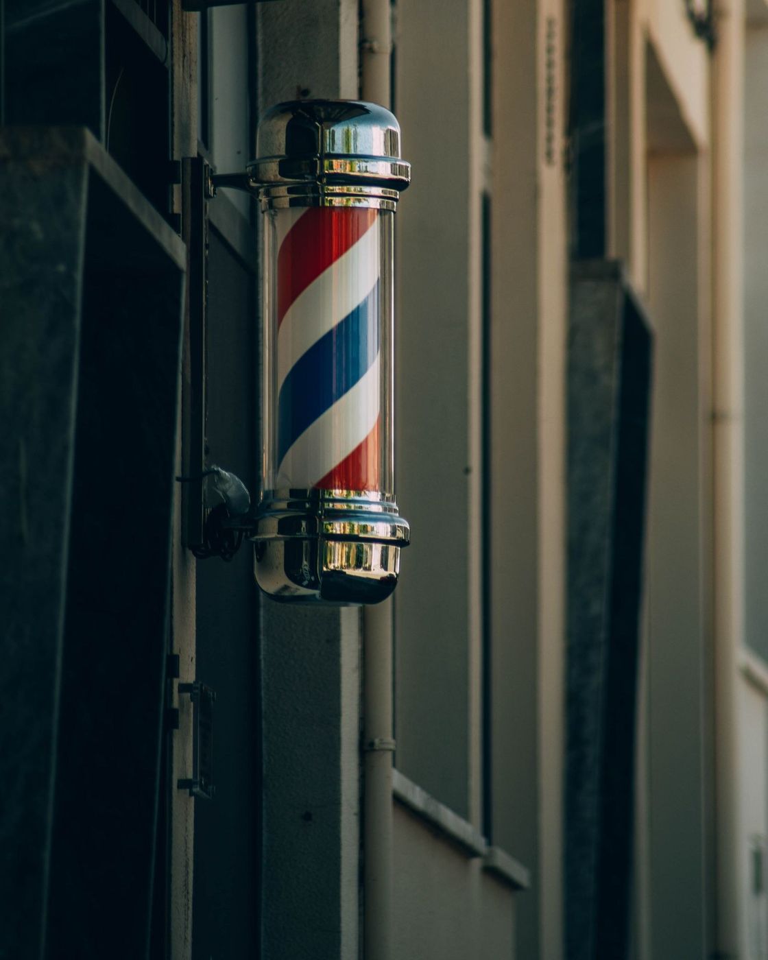 Poste giratório de barbearia preso na fachada de uma casa